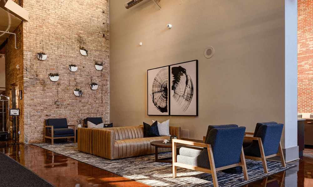 a lobby with a couch and chairs and a brick wall